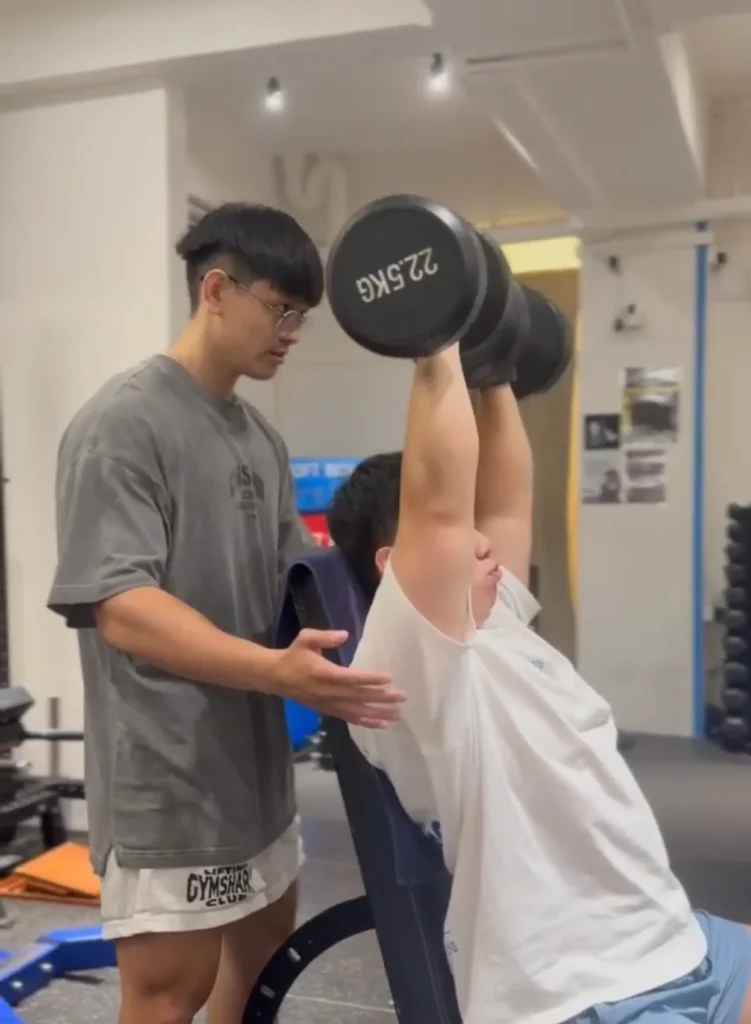 Bron guiding a client through a dumbbell exercise